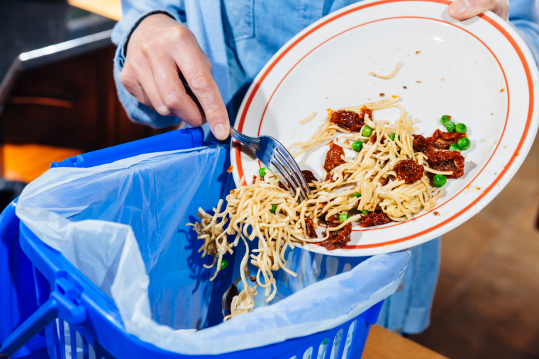 Scraping leftover food into bin