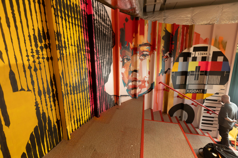 A colourful wall mural of faces and other patterns at the Dugdale Arts Centre