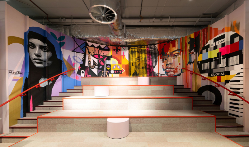 A colourful wall mural of faces and other patterns at the Dugdale Arts Centre