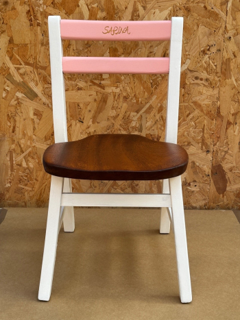 A chair that has been restored and personalised with the name Sakina on the back rest