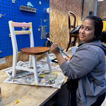 A woman painting a chair for her friend's daughter