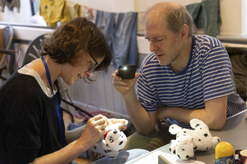 Fiona Dear repairing a stuffed toy for Laurie Hill