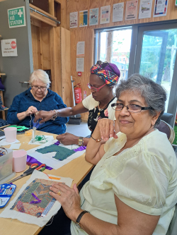 Pragna - a participant at Stitch Social smiling with her stitching