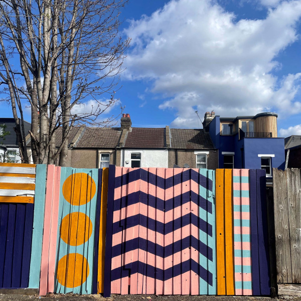 A colourful geometric design painted onto a back fence