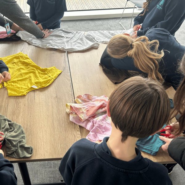 Students cutting t-shirts to make a t-shirt tote bag