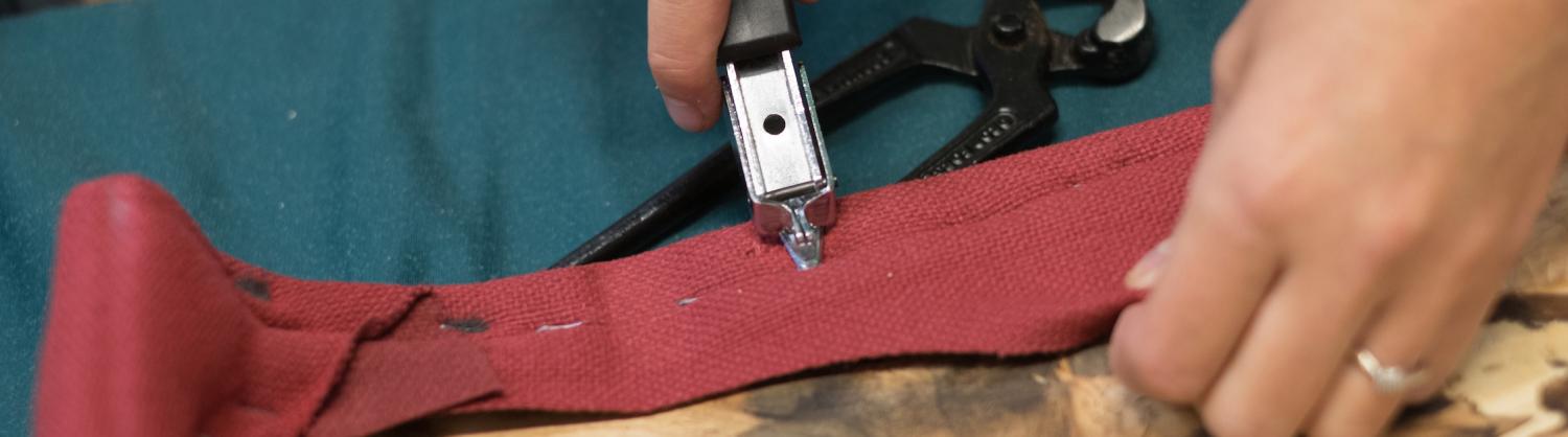 A repair specialist unpicks stitching at a Repair Cafe.