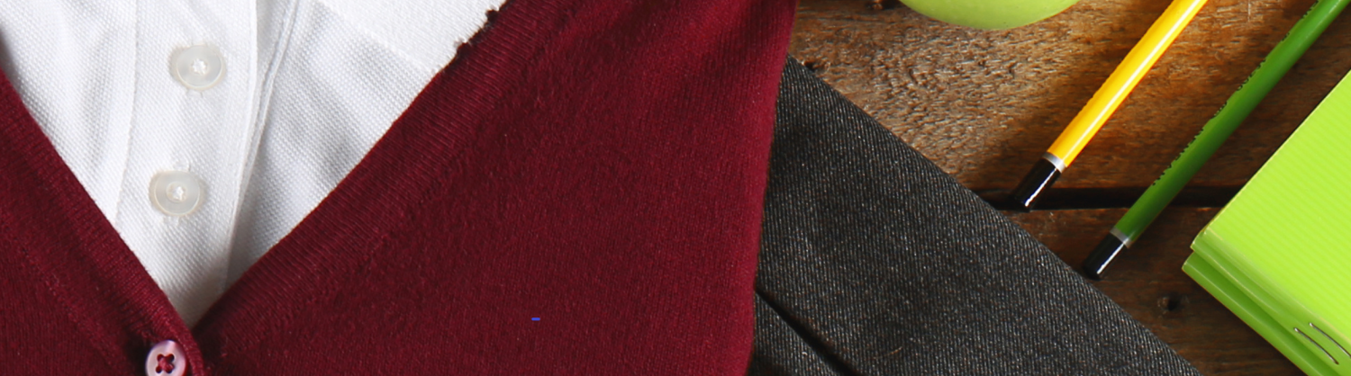 school uniform, an apple and stationary laid out on a table