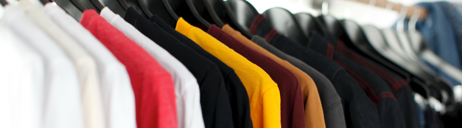 selection of coloured t-shirts on a clothes rail
