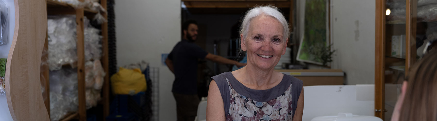 Image of person standing, smiling at the camera, folding reusable nappy