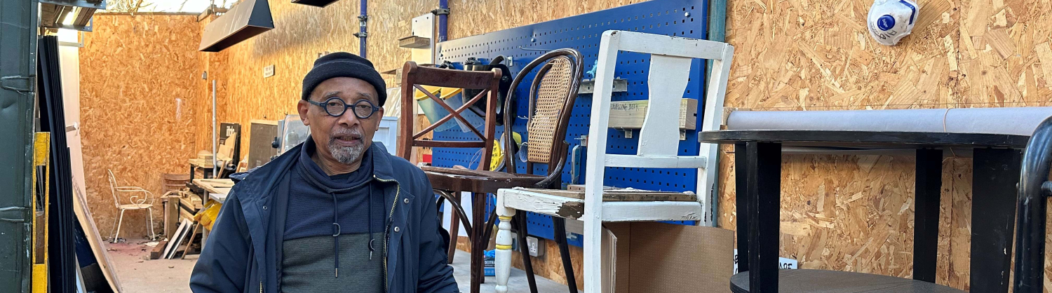 Huren Marsh in his workshop with second-hand furniture behind him