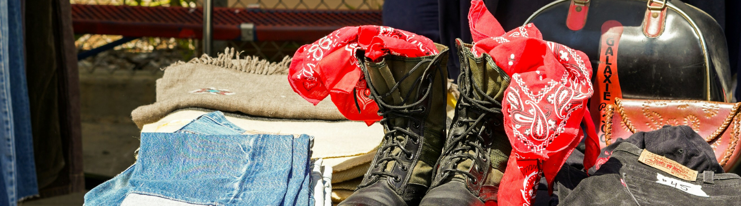 Some second-hand clothing for sale arranged on a bench