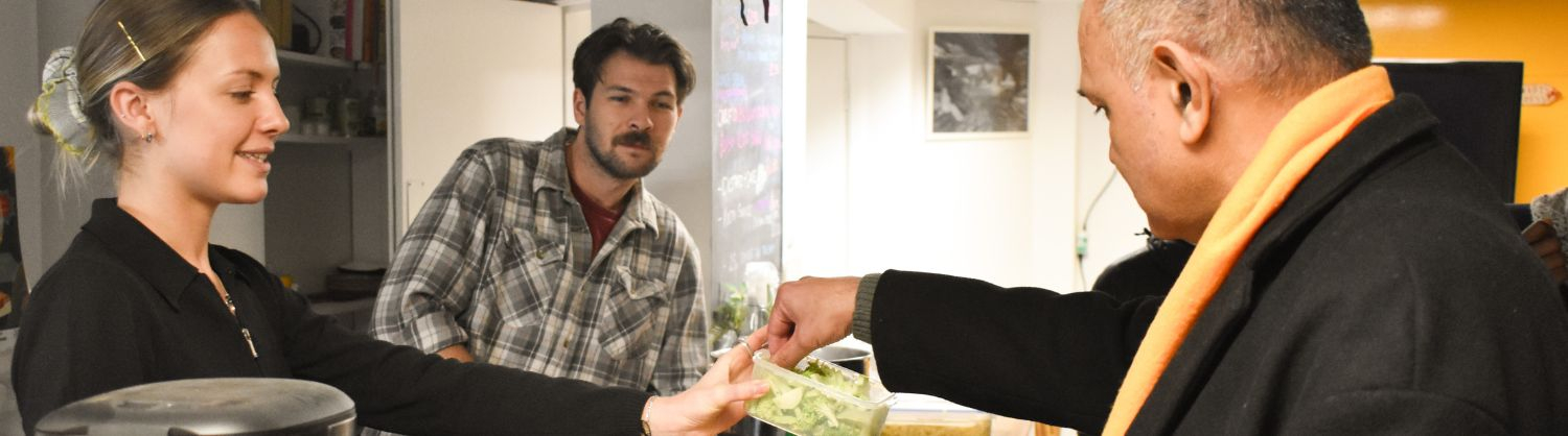 Three people sampling some chopped vegetables from a box
