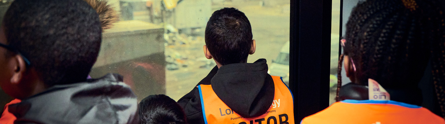 Group of children looking out of a window at a pile of rubbish