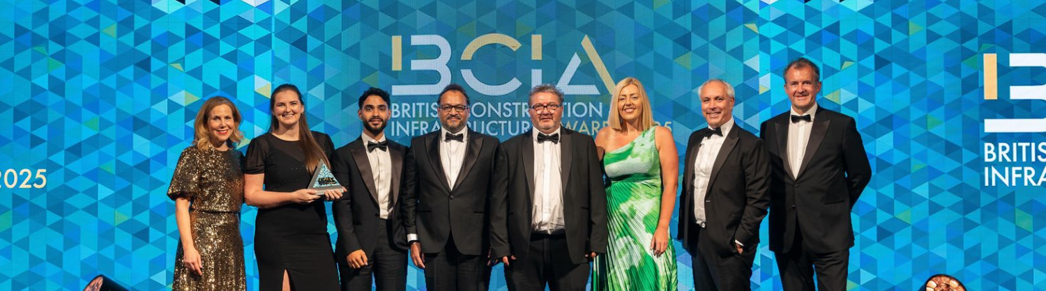 A group of people line up on-stage in front of an awards banner
