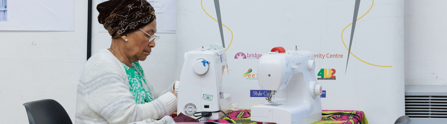 Sewn Together participant, sewing on a sewing machine 