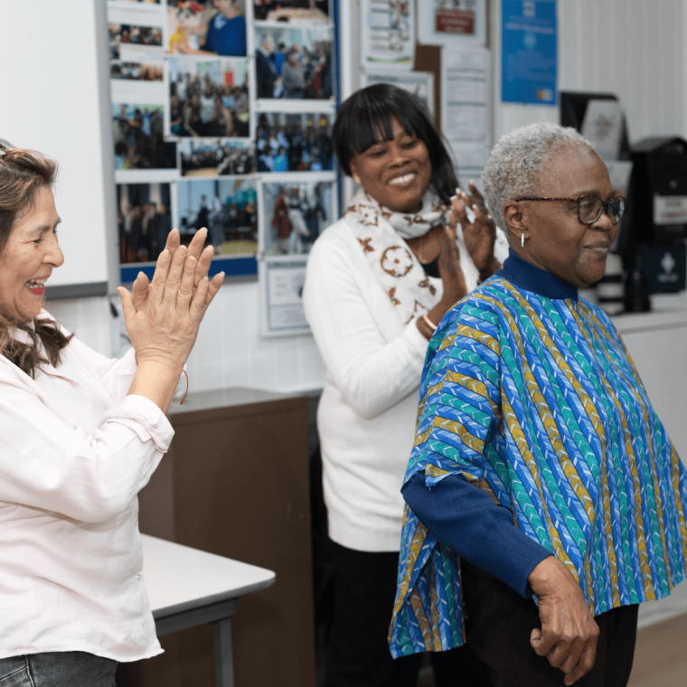 Attendee showing off a newly made blouse with the instructors clapping
