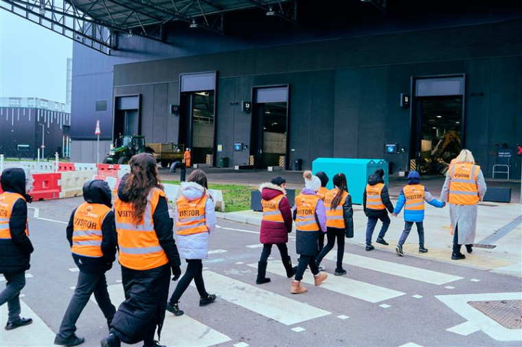 School children in high-vis jackets crossing the road