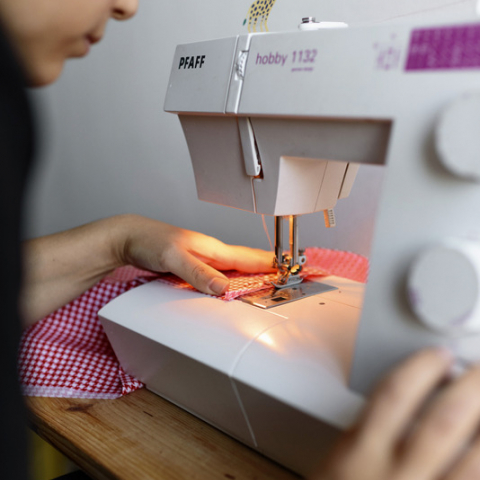 Woman repairing clothes with sewing machine