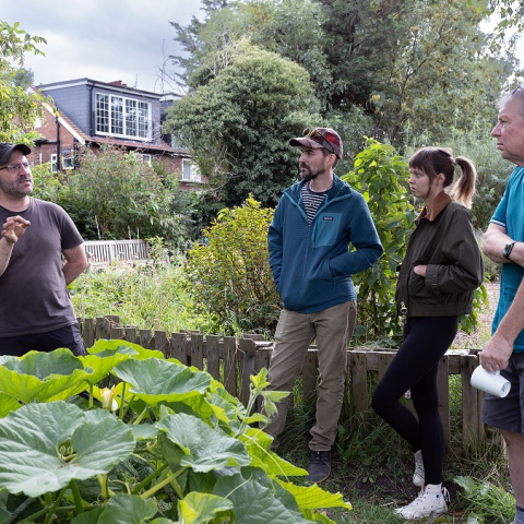 Image of four people standing outside talking in garden