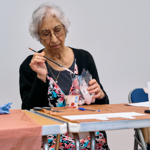 Attendee at the recycle art class at the first stage of making a planter from a plastic bottle 2024