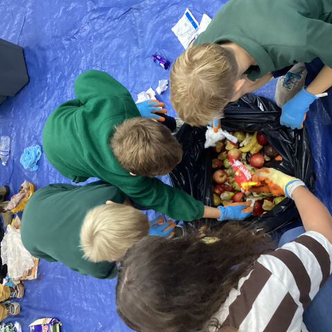 4 students looking through a bag of food waste