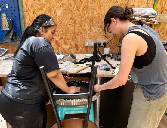 Women restoring a chair in workshop