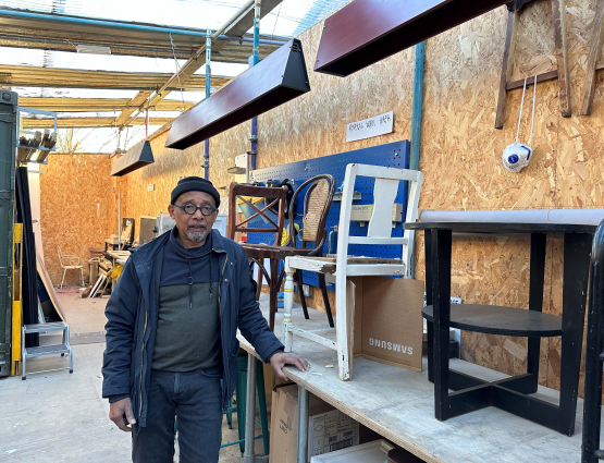 Huren Marsh in his workshop with second-hand furniture behind him