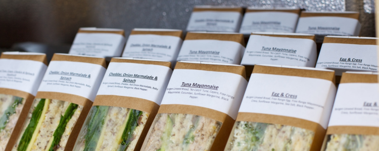 Lined up sandwiches in paper and plastic packaging
