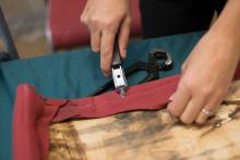 A repair specialist unpicks stitching at a Repair Cafe.