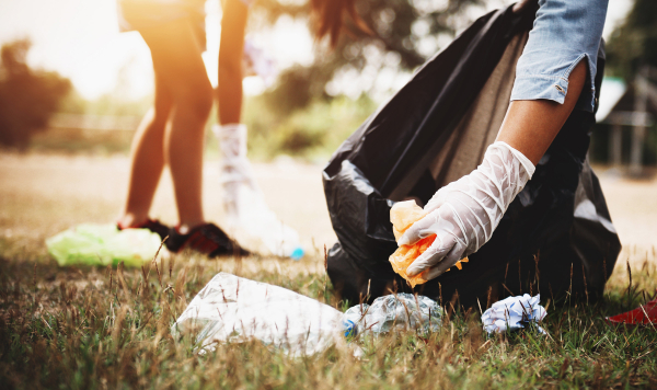 Plastic waste being placed in a bin liner.