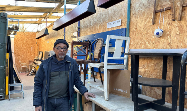 Huren Marsh in his workshop with second-hand furniture behind him